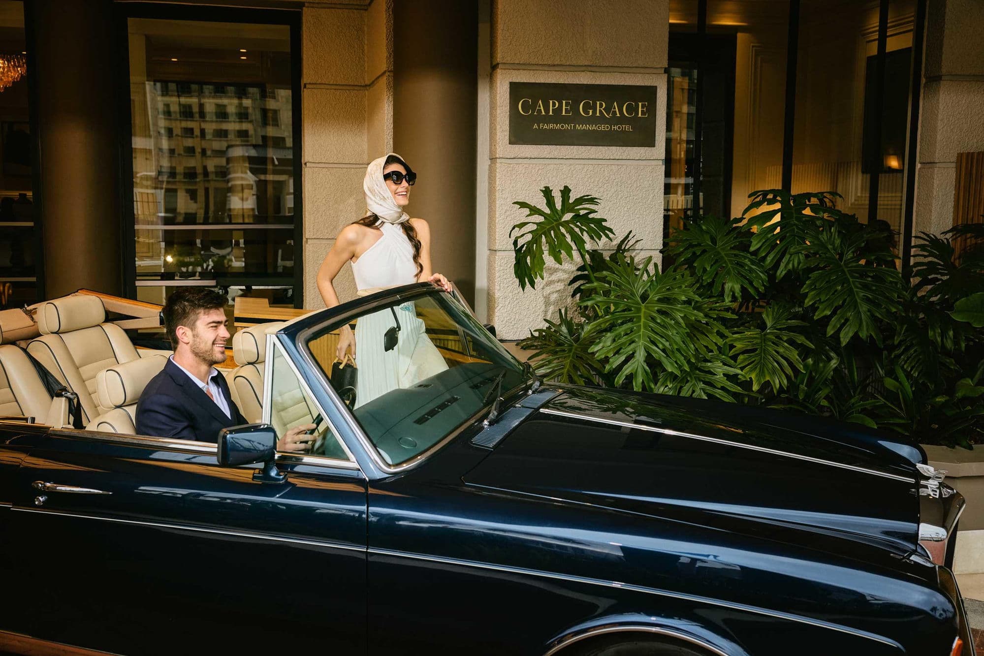 A couple arriving at Cape Grace in a vintage convertible